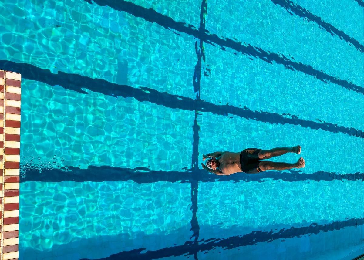 Woman performing high-knee jumps in chest-deep water during water aerobics weight loss intense pool session