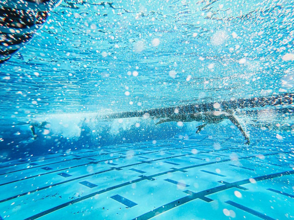 Woman performing water aerobics exercises in a pool, demonstrating benefits of water aerobics exercises for joint-friendly weight loss